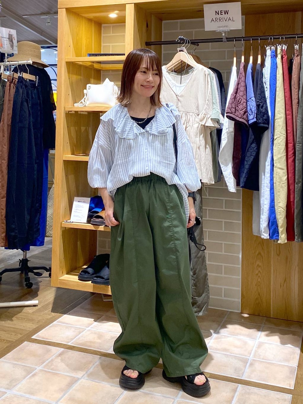 ブラック系のサンダル、グリーン系のその他パンツ、ブラック系のショルダーバッグを着用したレディースの夏コーディネートの1枚目の写真