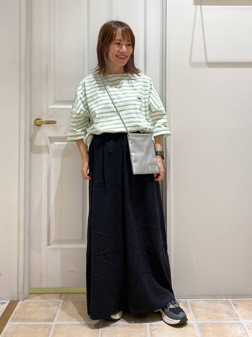 ブラック系のその他パンツ、その他のショルダーバッグ、ブラック系のスニーカーを着用したレディースの秋コーディネートの1枚目の写真