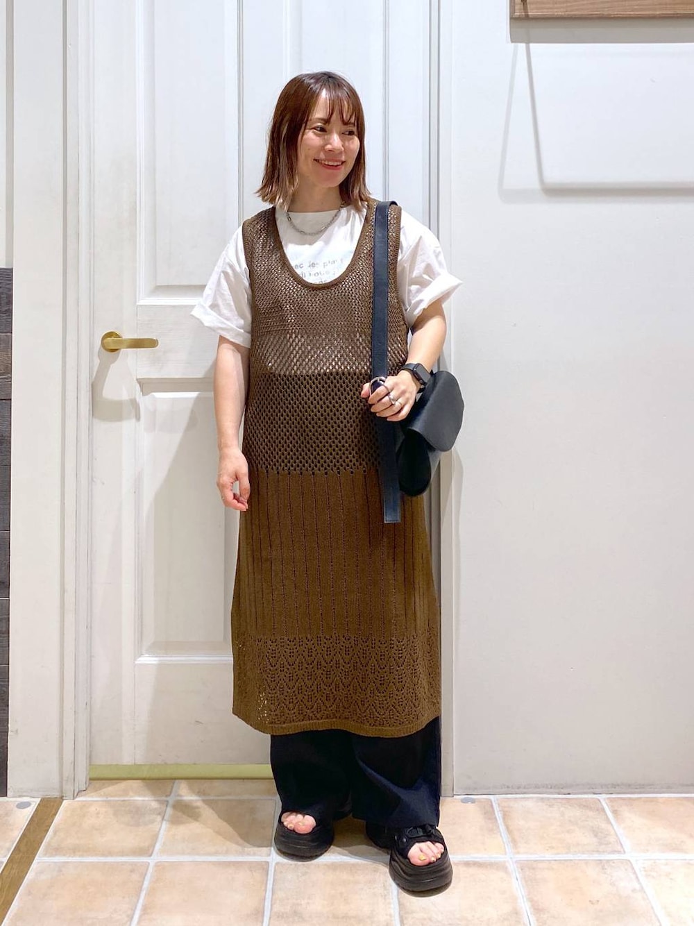 ブラック系のサンダル、ブラック系のその他パンツ、ホワイト系のTシャツ/カットソーを着用したレディースの夏コーディネートの1枚目の写真