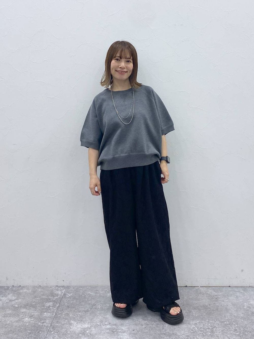 ブラック系のサンダル、グレー系のスウェット、ブラック系のその他パンツを着用したレディースの秋コーディネートの1枚目の写真