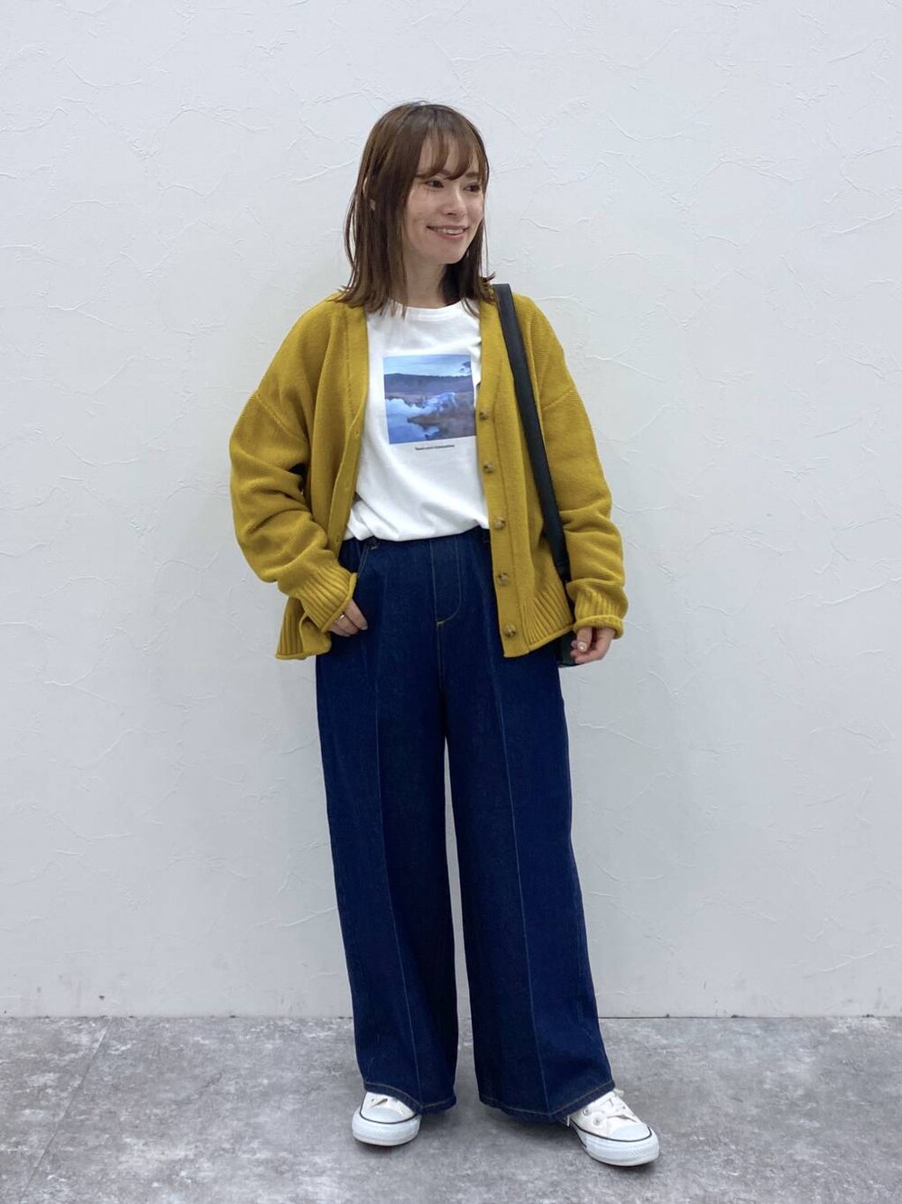 ブルー系のデニムパンツ、イエロー系のカーディガン/ボレロ、その他のTシャツ/カットソーを着用したレディースの秋コーディネートの1枚目の写真