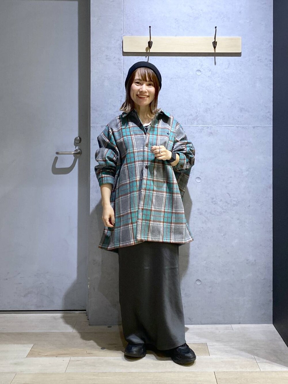 グレー系のスカート、ブラック系のスニーカー、グレー系のシャツ/ブラウスを着用したレディースの秋コーディネートの1枚目の写真