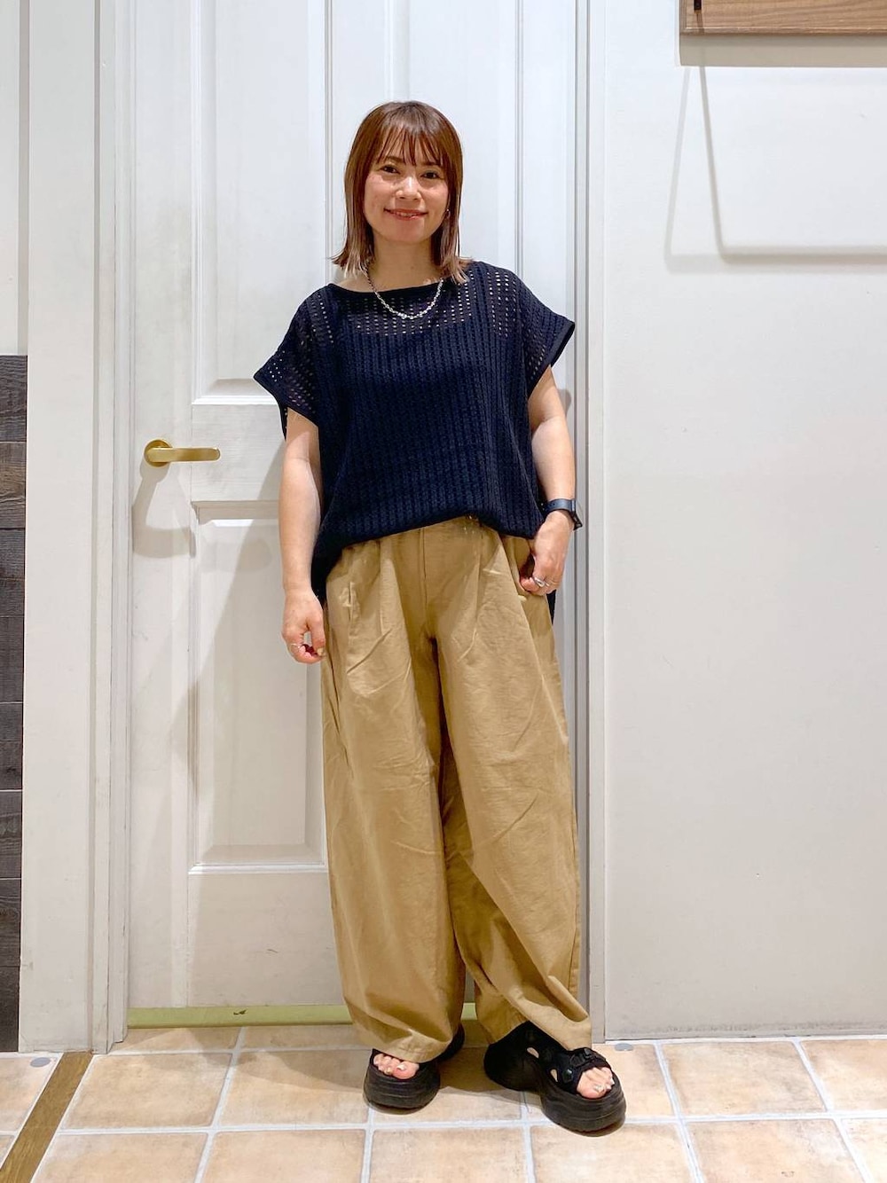 ブラック系のサンダル、ベージュ系のその他パンツ、ブラック系のTシャツ/カットソーを着用したレディースの夏コーディネートの1枚目の写真