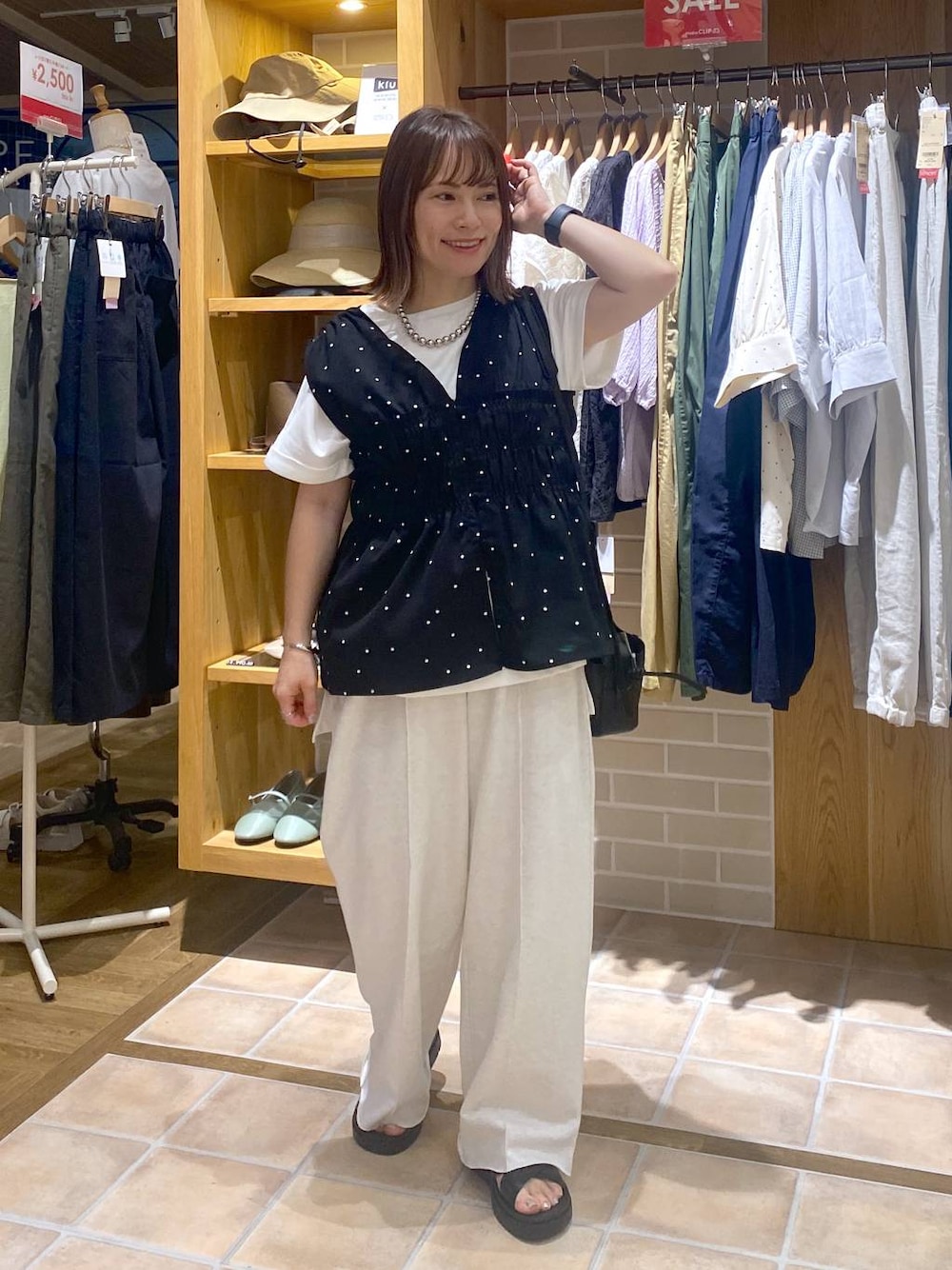 ブラック系のサンダル、ブラック系のその他パンツ、ホワイト系のTシャツ/カットソーを着用したレディースの夏コーディネートの1枚目の写真