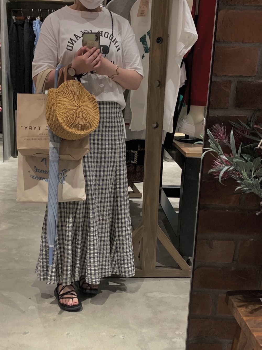 ベージュ系のスカート、ホワイト系のTシャツ/カットソー、ブラック系のサンダルを着用したレディースの夏コーディネートの1枚目の写真