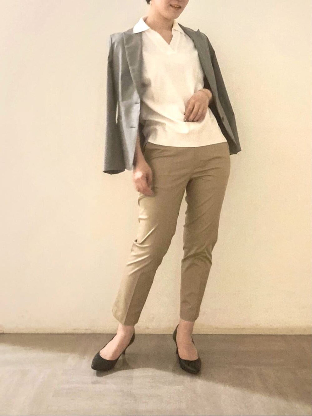 ベージュ系のチノパンツ、グレー系のテーラードジャケット、ホワイト系のポロシャツを着用したレディースの夏コーディネートの1枚目の写真