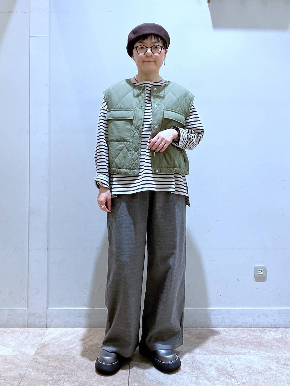グリーン系のベスト、その他のその他シューズ、その他のTシャツ/カットソーを着用したレディースの秋コーディネートの1枚目の写真