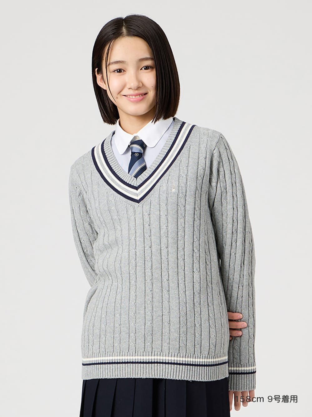 ホワイト系のシャツ/ブラウス、ブルー系のスカート、グレー系のニット/セーターを着用したレディースの冬コーディネートの1枚目の写真