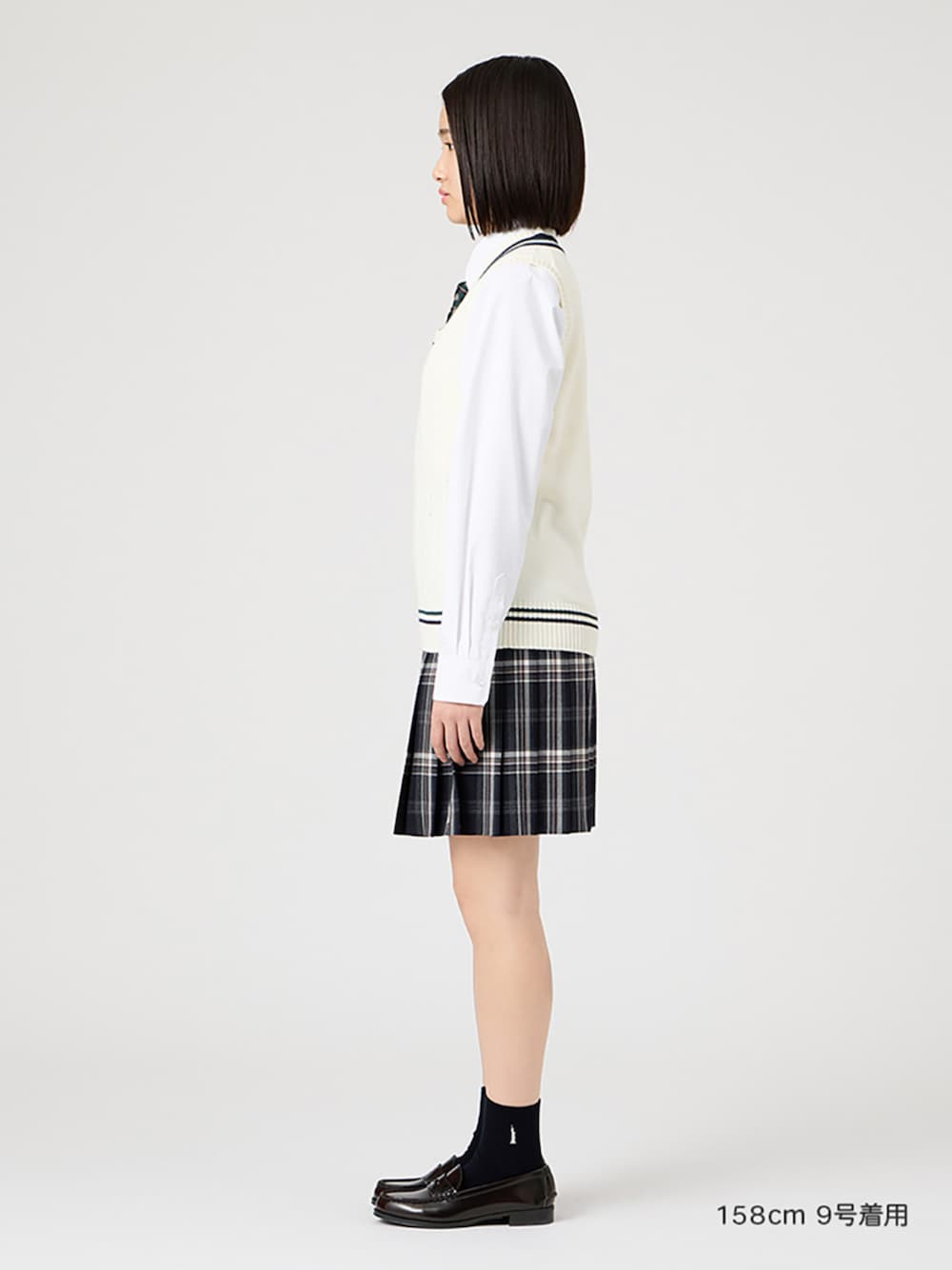 ブラウン系のローファー、ホワイト系のシャツ/ブラウス、ホワイト系のベストを着用したレディースの冬コーディネートの1枚目の写真