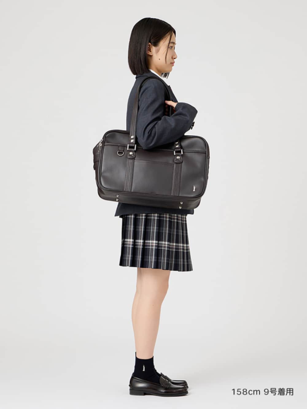 ブラウン系のローファー、グレー系のテーラードジャケット、ブラウン系のショルダーバッグを着用したレディースの春コーディネートの1枚目の写真