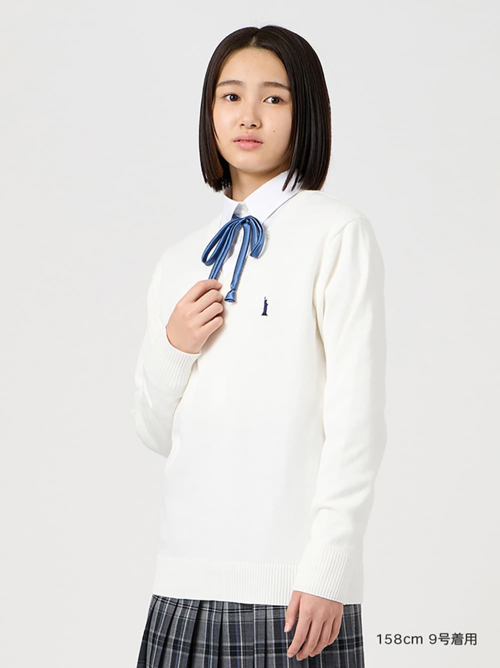 ホワイト系のシャツ/ブラウス、グレー系のスカート、ホワイト系のニット/セーターを着用したレディースの冬コーディネートの1枚目の写真