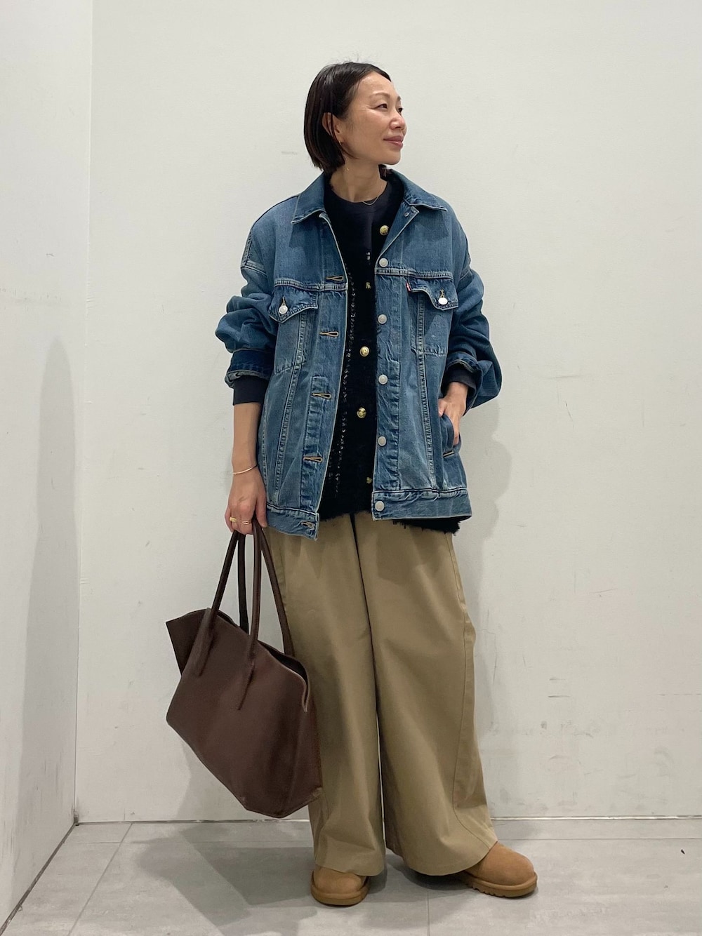 ブルー系のデニムジャケット、ベージュ系のその他パンツ、ブラック系のTシャツ/カットソーを着用したレディースの秋コーディネートの1枚目の写真