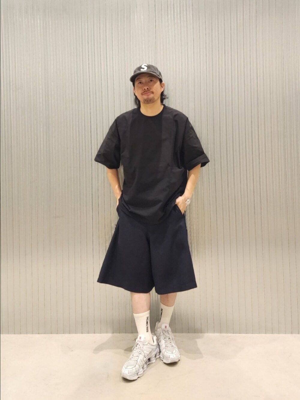 ブラック系のTシャツ/カットソーを着用したメンズの夏コーディネートの1枚目の写真