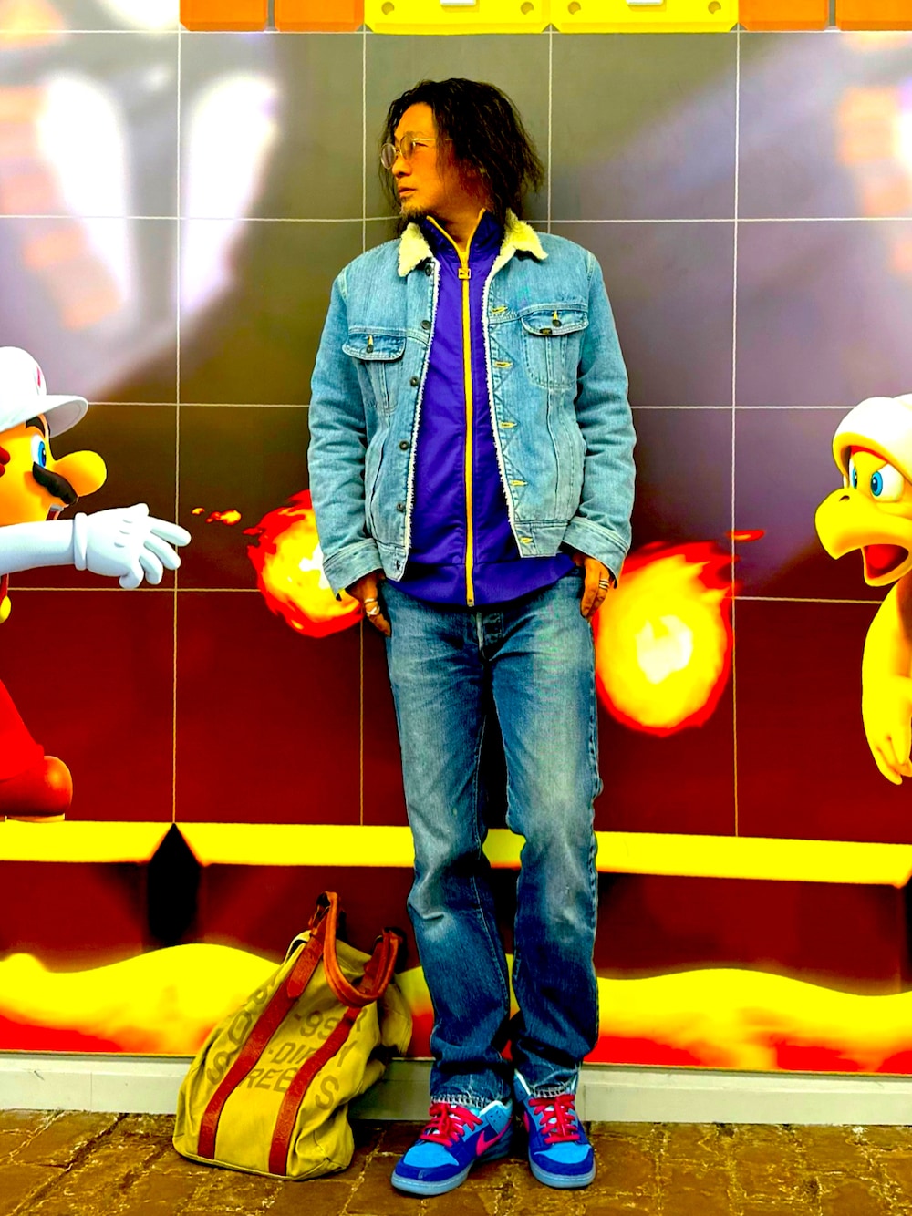 パープル系のジャージ、ブルー系のスニーカー、グリーン系のトートバッグを着用したメンズの春コーディネートの1枚目の写真