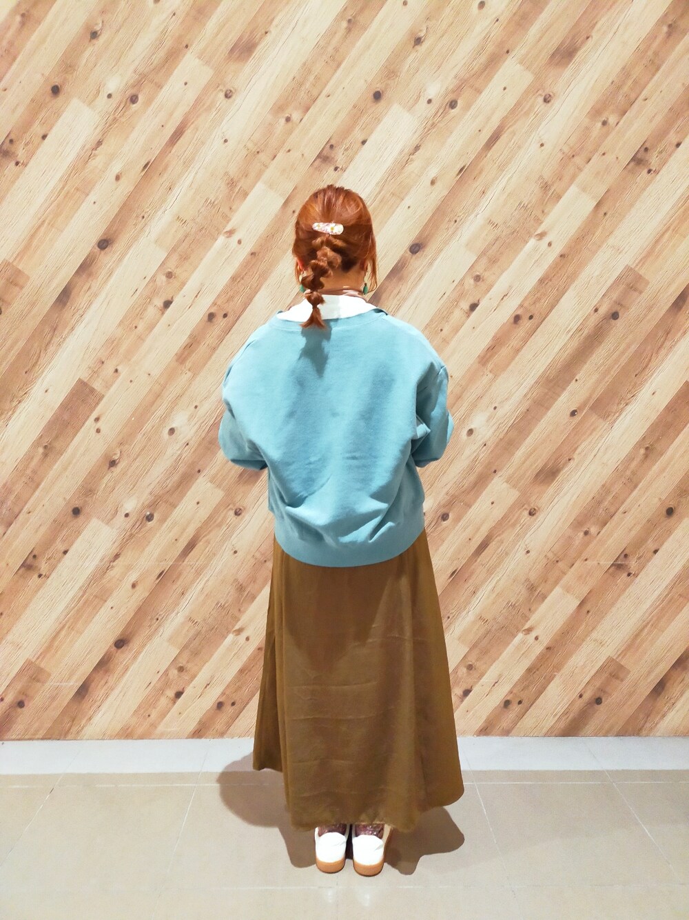 ブルー系のカーディガン/ボレロ、グリーン系のスカート、グリーン系のショルダーバッグを着用したレディースの冬コーディネートの2枚目の写真