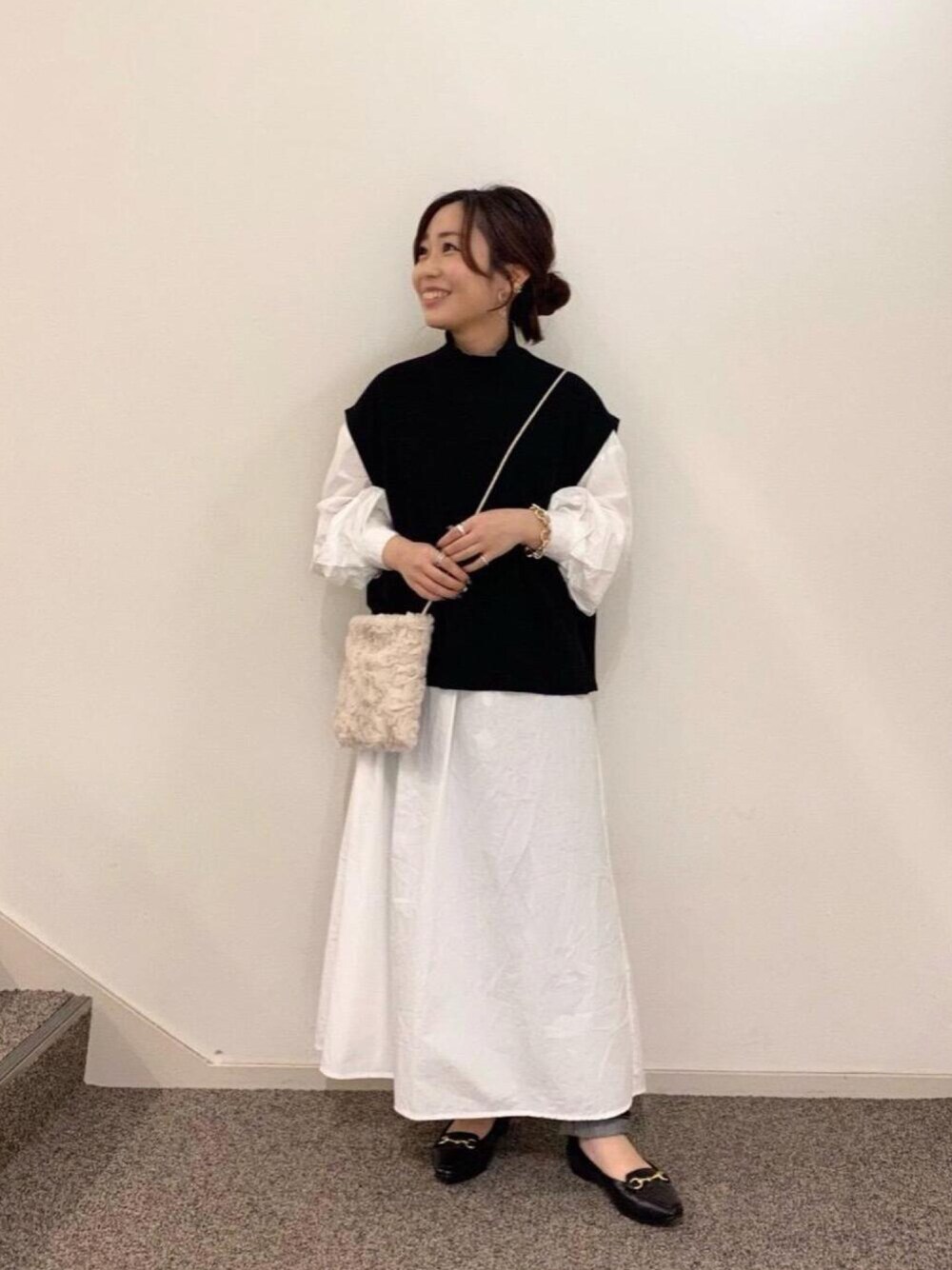 ブルー系のデニムパンツ、ブラック系のローファー、ホワイト系のワンピースを着用したレディースの秋コーディネートの1枚目の写真