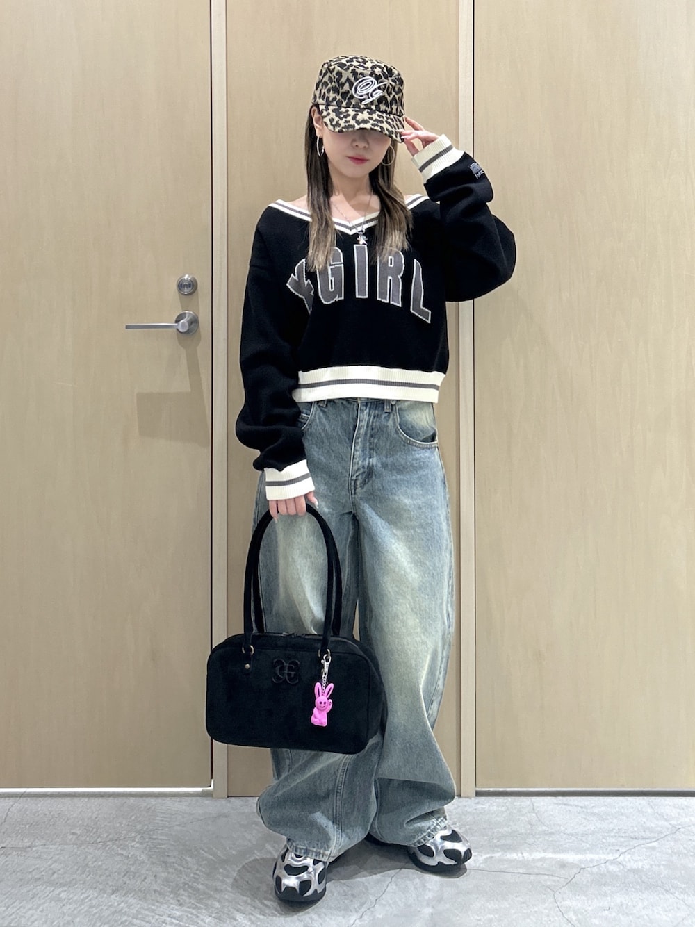 ブラック系のニット/セーター、ブルー系のデニムパンツ、ブラック系のハンドバッグを着用したレディースの秋コーディネートの1枚目の写真