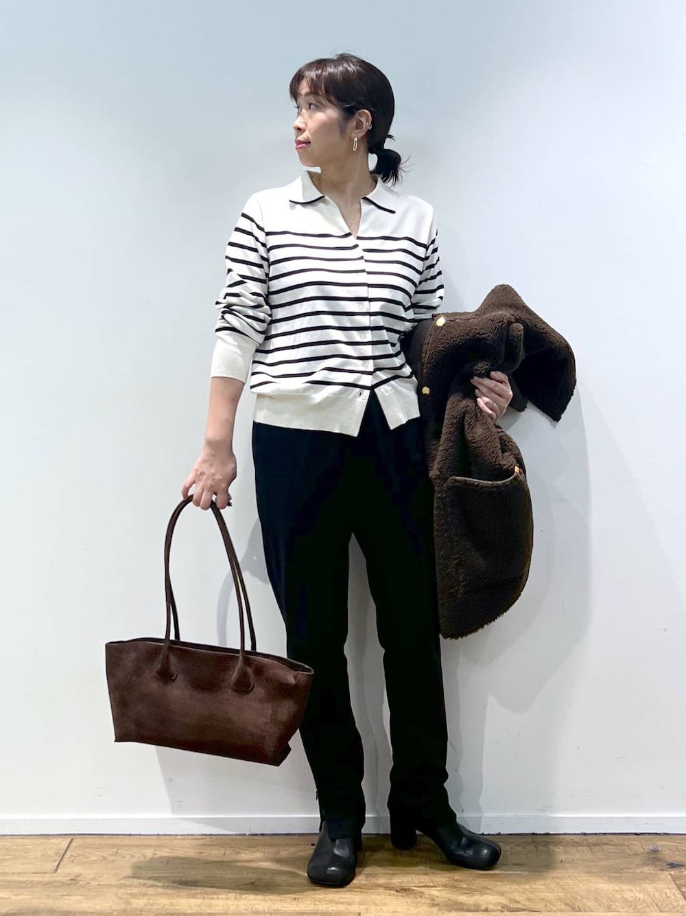 ブラック系のその他パンツ、ホワイト系のニット/セーター、その他のピアス(両耳用)を着用したレディースの秋コーディネートの1枚目の写真