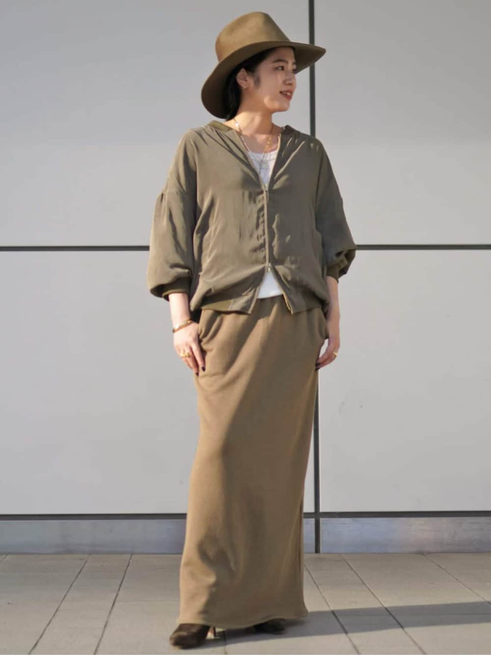 グリーン系のその他アウター、ベージュ系のハットを着用したレディースの秋コーディネートの1枚目の写真