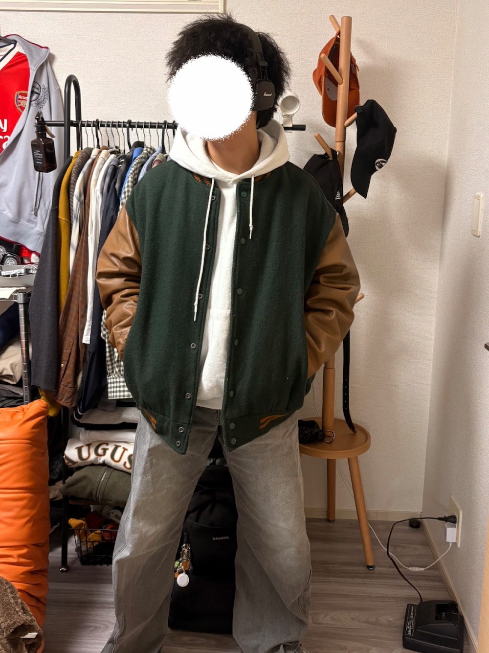 ホワイト系のパーカー、グリーン系のブルゾン、グレー系のデニムパンツを着用したメンズの秋コーディネートの1枚目の写真