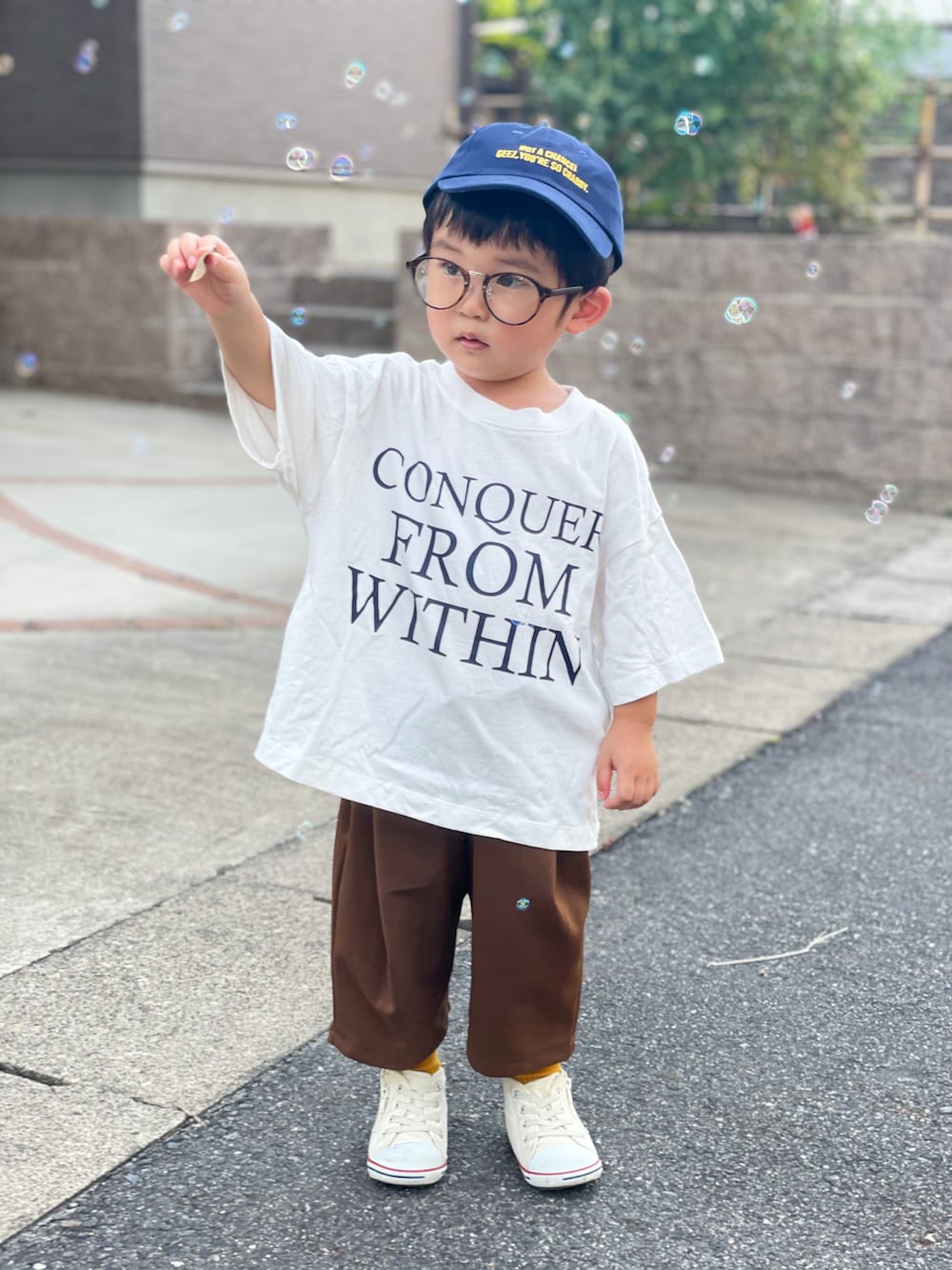 ホワイト系のTシャツ/カットソー、ブラウン系のパンツ、ホワイト系のスニーカーを着用したキッズの秋コーディネートの1枚目の写真