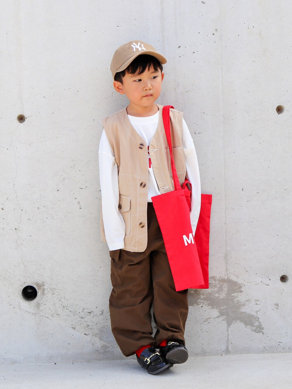 ホワイト系のTシャツ/カットソー、ベージュ系のベスト、ブラウン系のカーゴパンツを着用したキッズの秋コーディネートの1枚目の写真