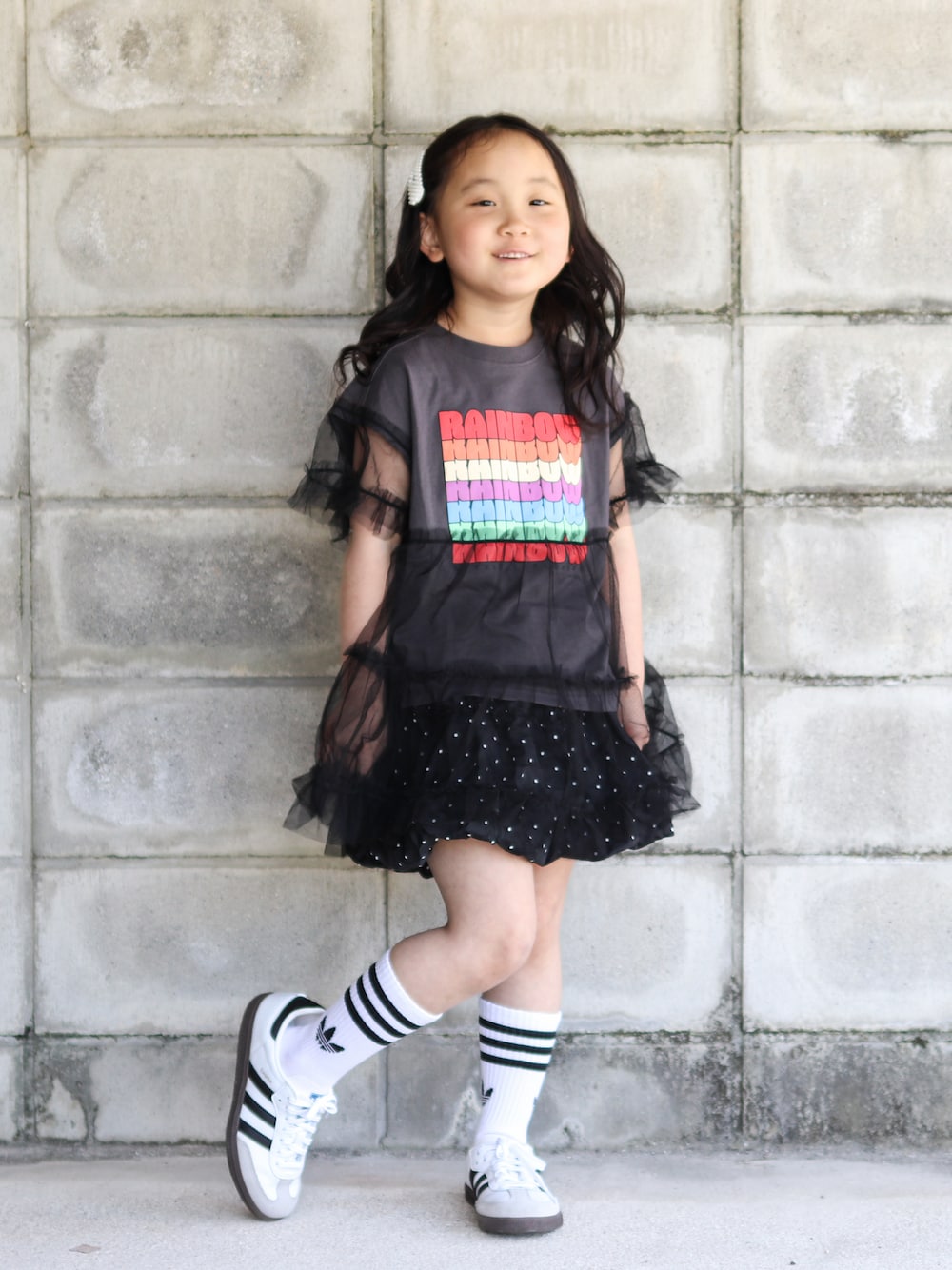 グレー系のTシャツ/カットソー、ブラック系のスカート、ホワイト系のスニーカーを着用したキッズの夏コーディネートの1枚目の写真