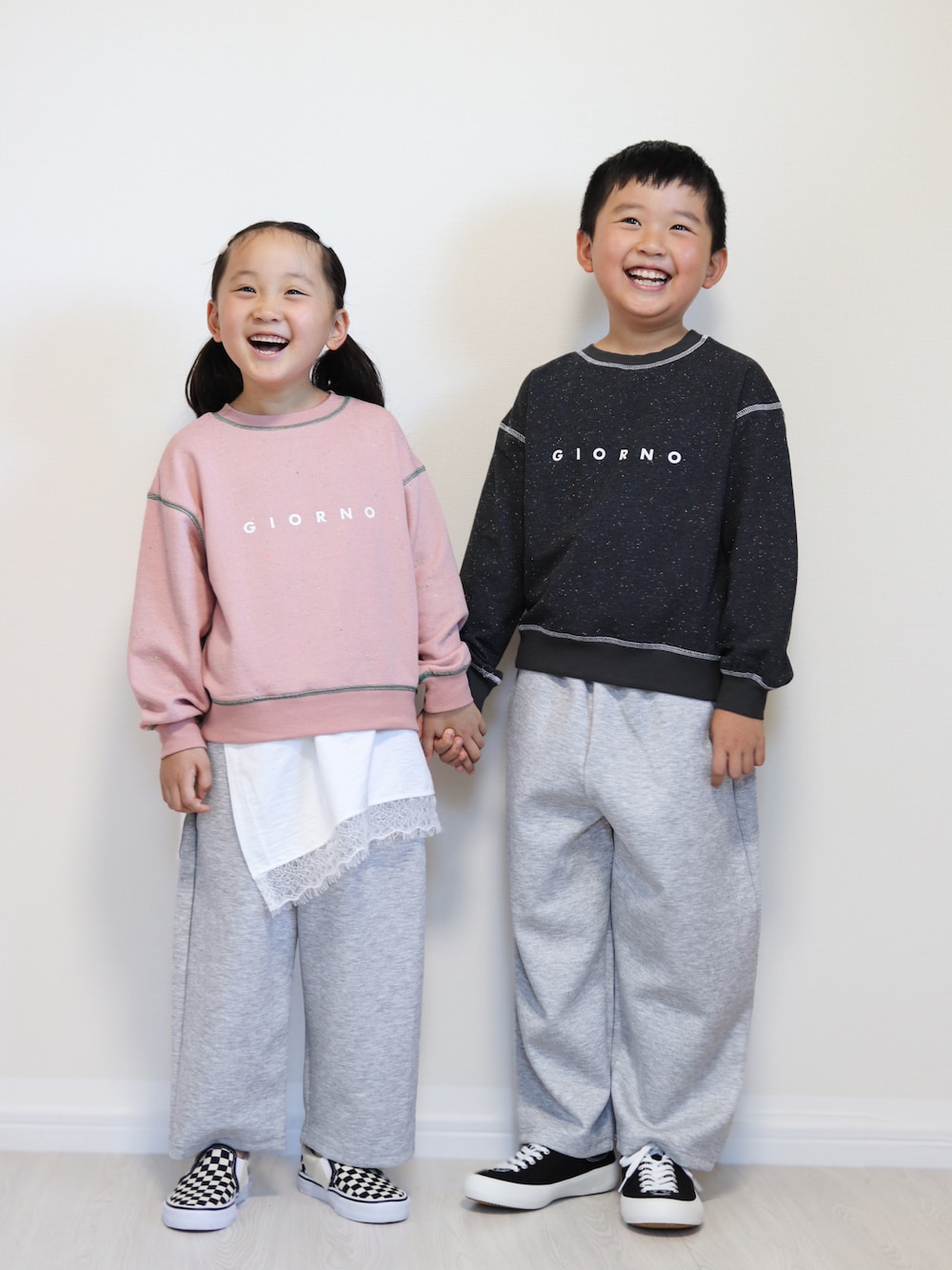 ピンク系のパーカー、ホワイト系のTシャツ/カットソー、グレー系のスウェットパンツを着用したキッズの秋コーディネートの1枚目の写真