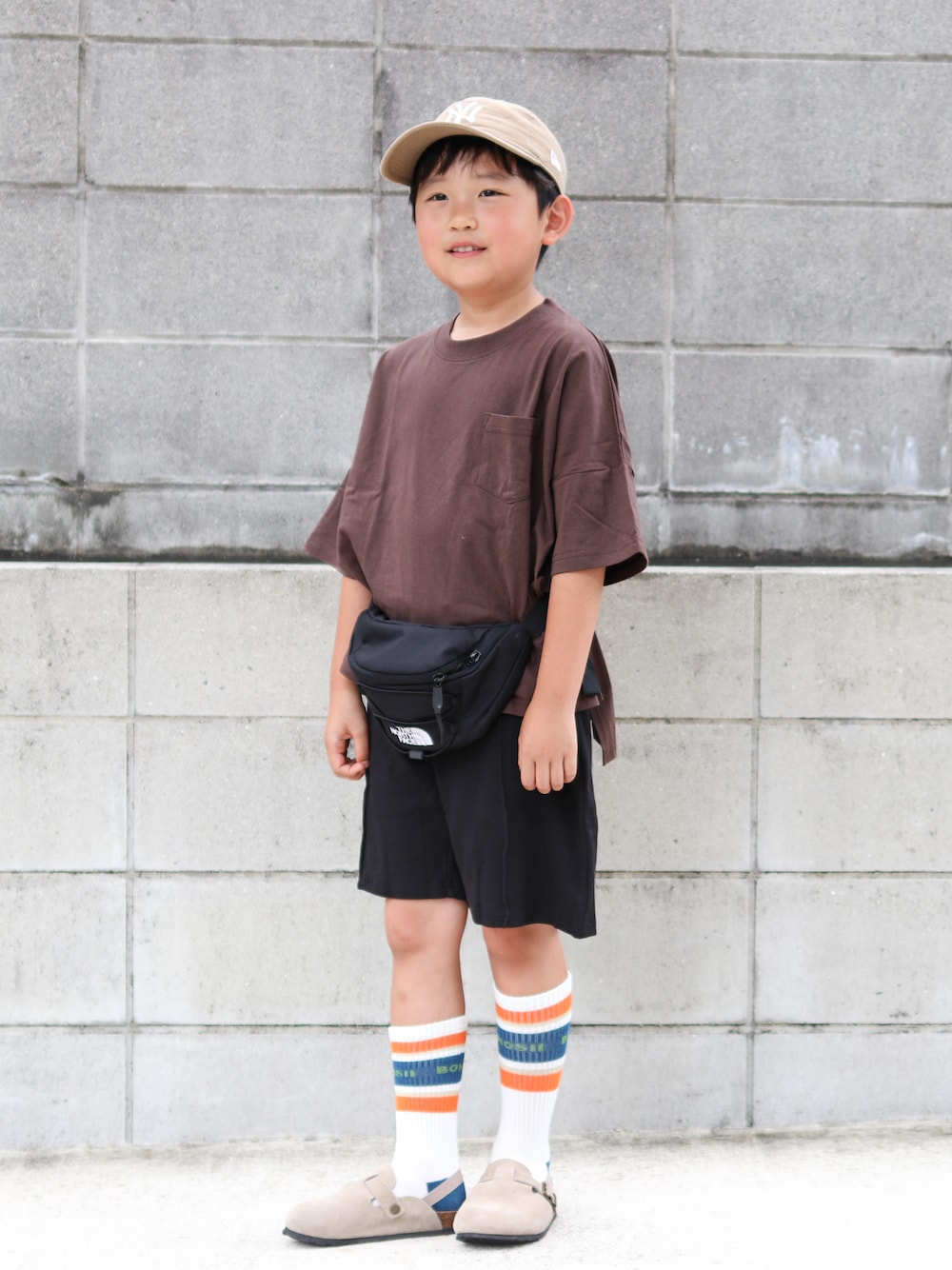 ブラウン系のTシャツ/カットソー、ブラック系のその他パンツ、ブラック系のボディバッグ/ウエストポーチを着用したキッズの夏コーディネートの1枚目の写真