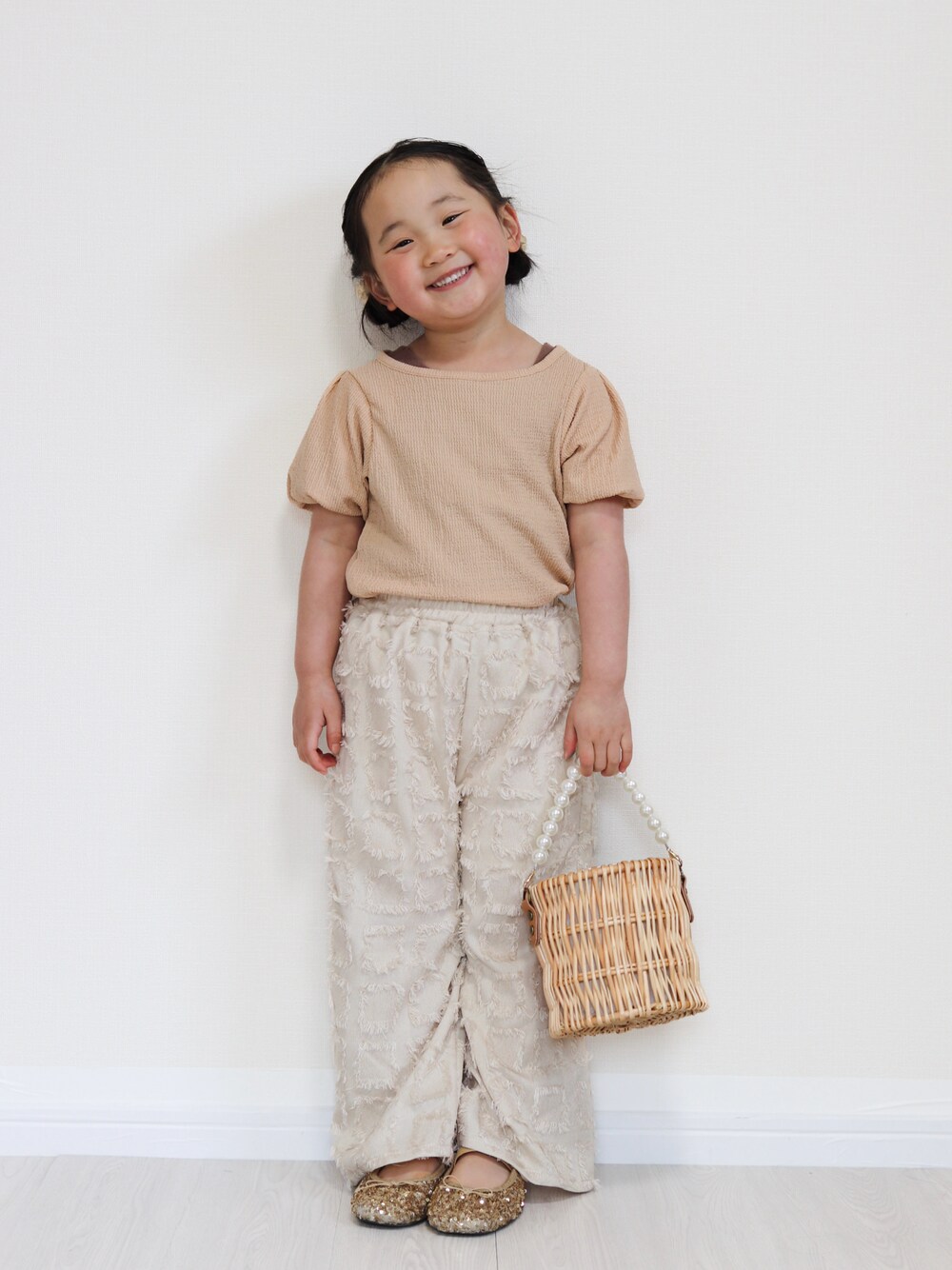 ピンク系のTシャツ/カットソー、ベージュ系のその他パンツ、ブラウン系のタンクトップを着用したキッズの春コーディネートの1枚目の写真