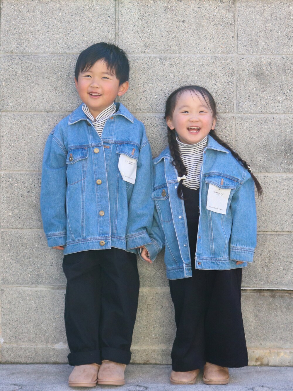 ブルー系のデニムジャケット、ホワイト系のトップス、ブラック系のサロペット/オーバーオールを着用したキッズの冬コーディネートの1枚目の写真