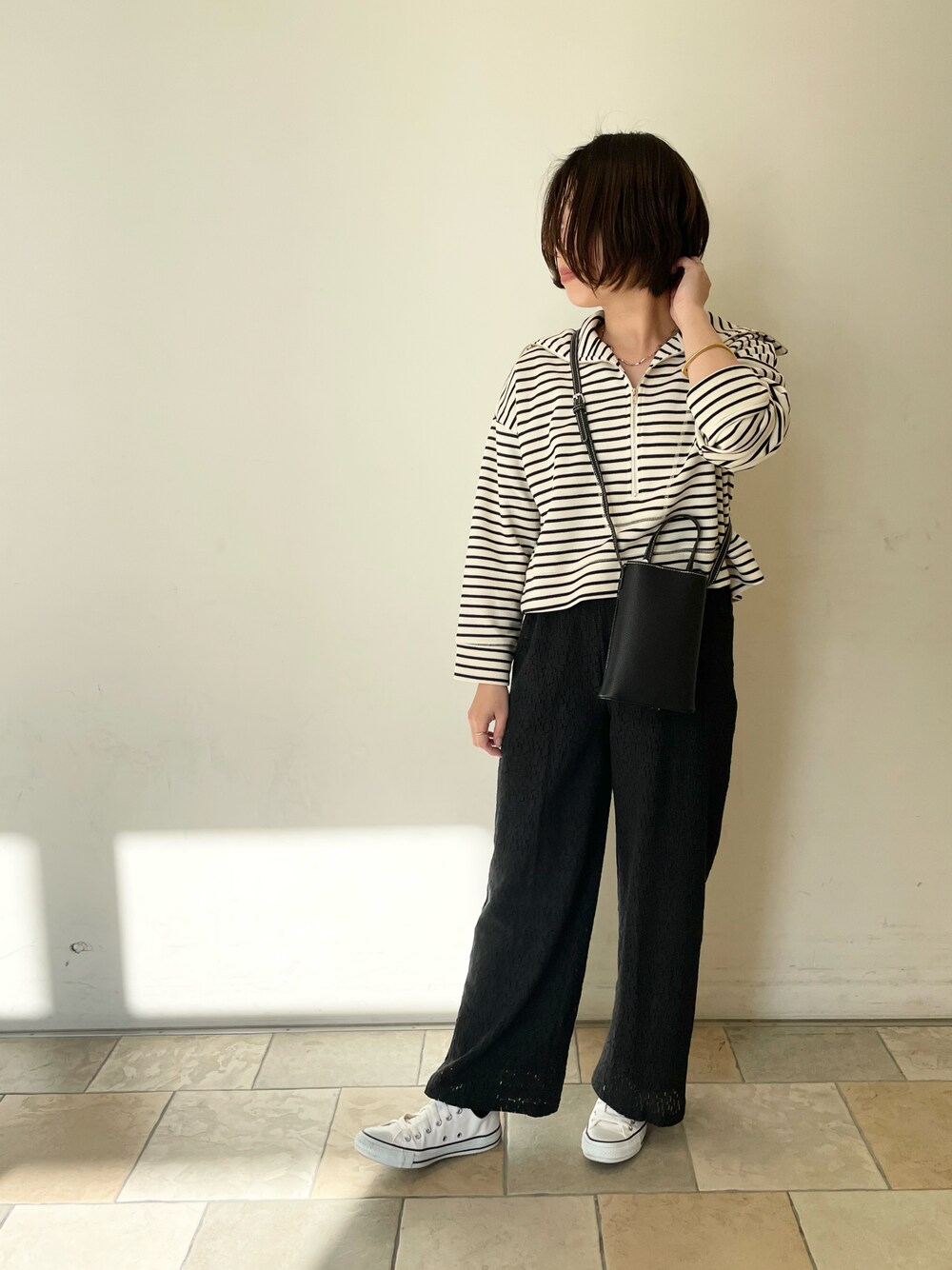 ブラック系のその他パンツ、ホワイト系のシューズ、ブラック系のショルダーバッグを着用したレディースの冬コーディネートの1枚目の写真