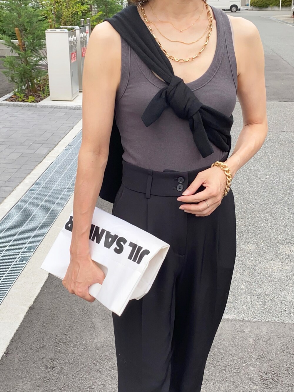 グレー系のタンクトップ、ゴールド系のブレスレットを着用したレディースの夏コーディネートの1枚目の写真