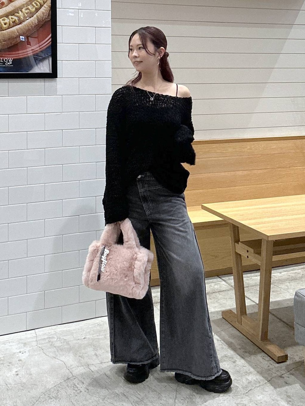 ブラック系のニット/セーター、ブラック系のデニムパンツ、ピンク系のトートバッグを着用したレディースの秋コーディネートの1枚目の写真