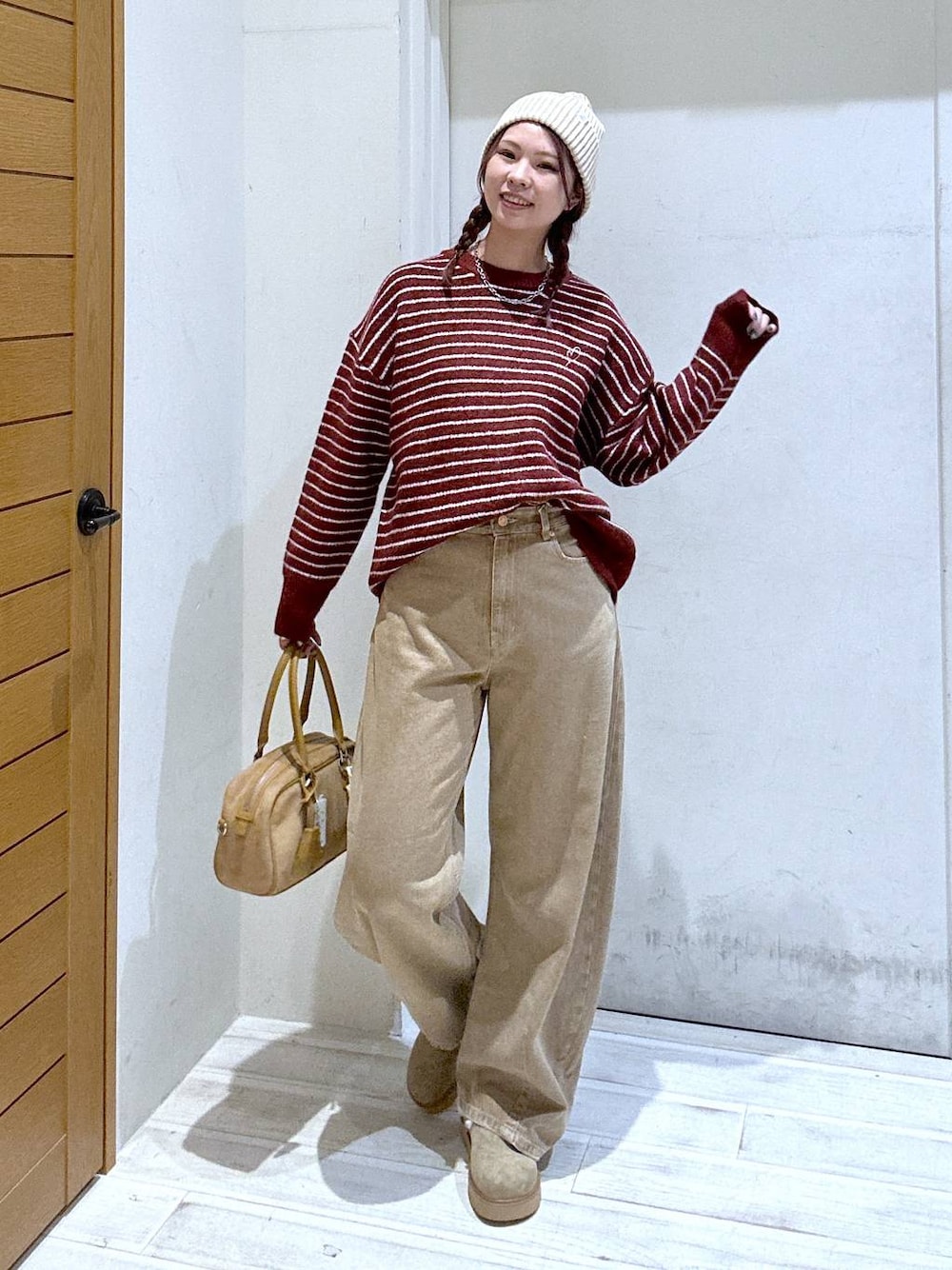 イエロー系のデニムパンツ、ベージュ系のその他シューズ、ベージュ系のハンドバッグを着用したレディースの秋コーディネートの1枚目の写真