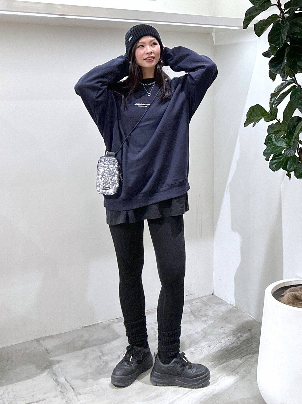 グレー系のショルダーバッグ、ブラック系のスニーカー、ブルー系のスウェットを着用したレディースの冬コーディネートの1枚目の写真
