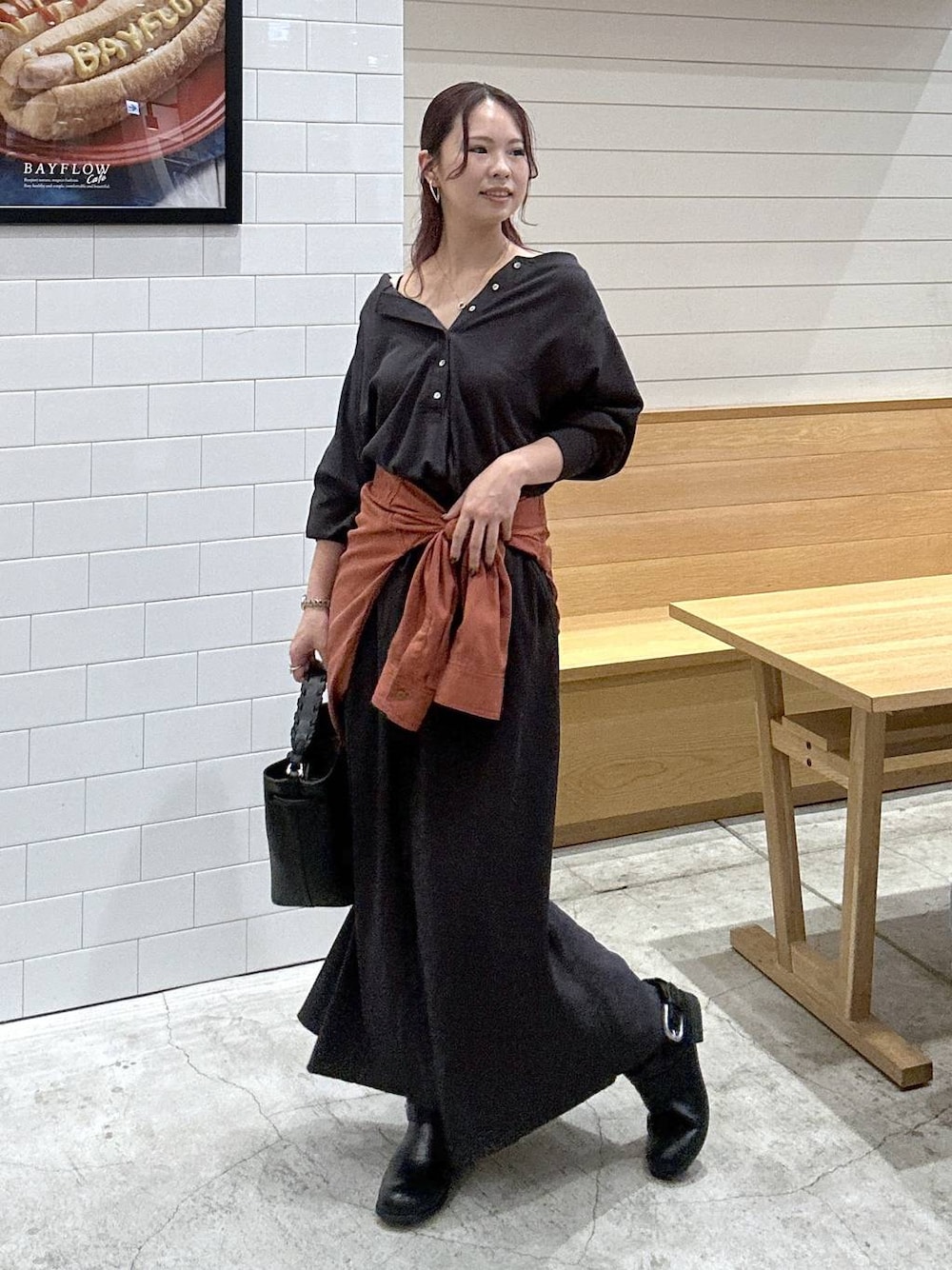 ブラック系のブーツ、グレー系のTシャツ/カットソー、グレー系のスカートを着用したレディースの秋コーディネートの1枚目の写真
