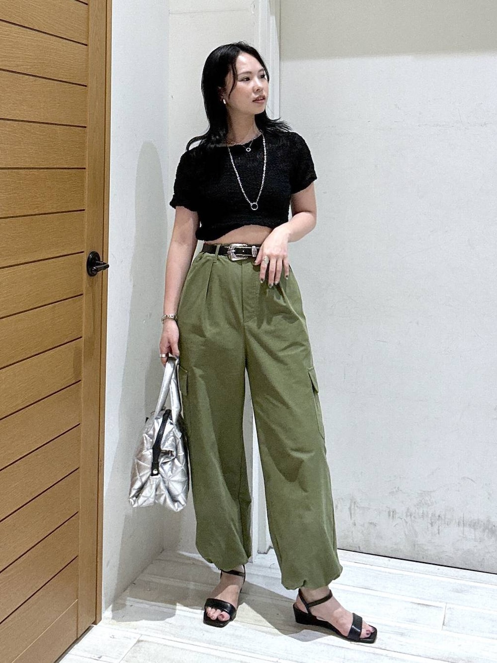 グリーン系のカーゴパンツ、ブラック系のサンダル、ブラック系のTシャツ/カットソーを着用したレディースの夏コーディネートの1枚目の写真