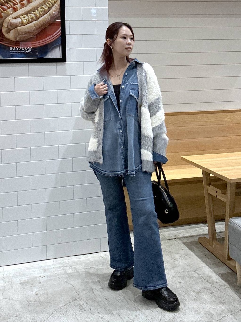 グレー系のカーディガン/ボレロ、ブルー系のシャツ/ブラウス、ブラック系のハンドバッグを着用したレディースの秋コーディネートの1枚目の写真