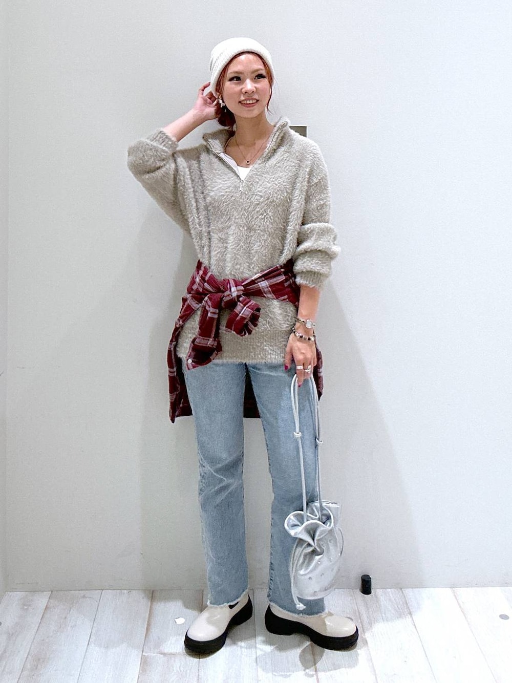 レッド系のシャツ/ブラウス、ブルー系のデニムパンツ、シルバー系のショルダーバッグを着用したレディースの秋コーディネートの1枚目の写真