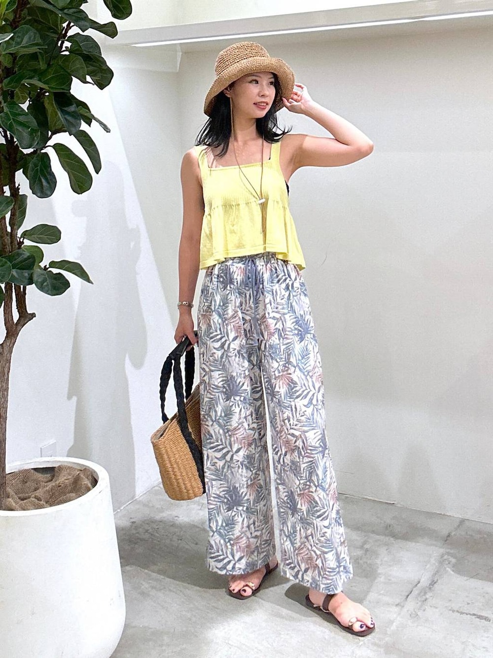 ブラウン系のトートバッグ、グリーン系のその他パンツ、ブラウン系のサンダルを着用したレディースの夏コーディネートの1枚目の写真