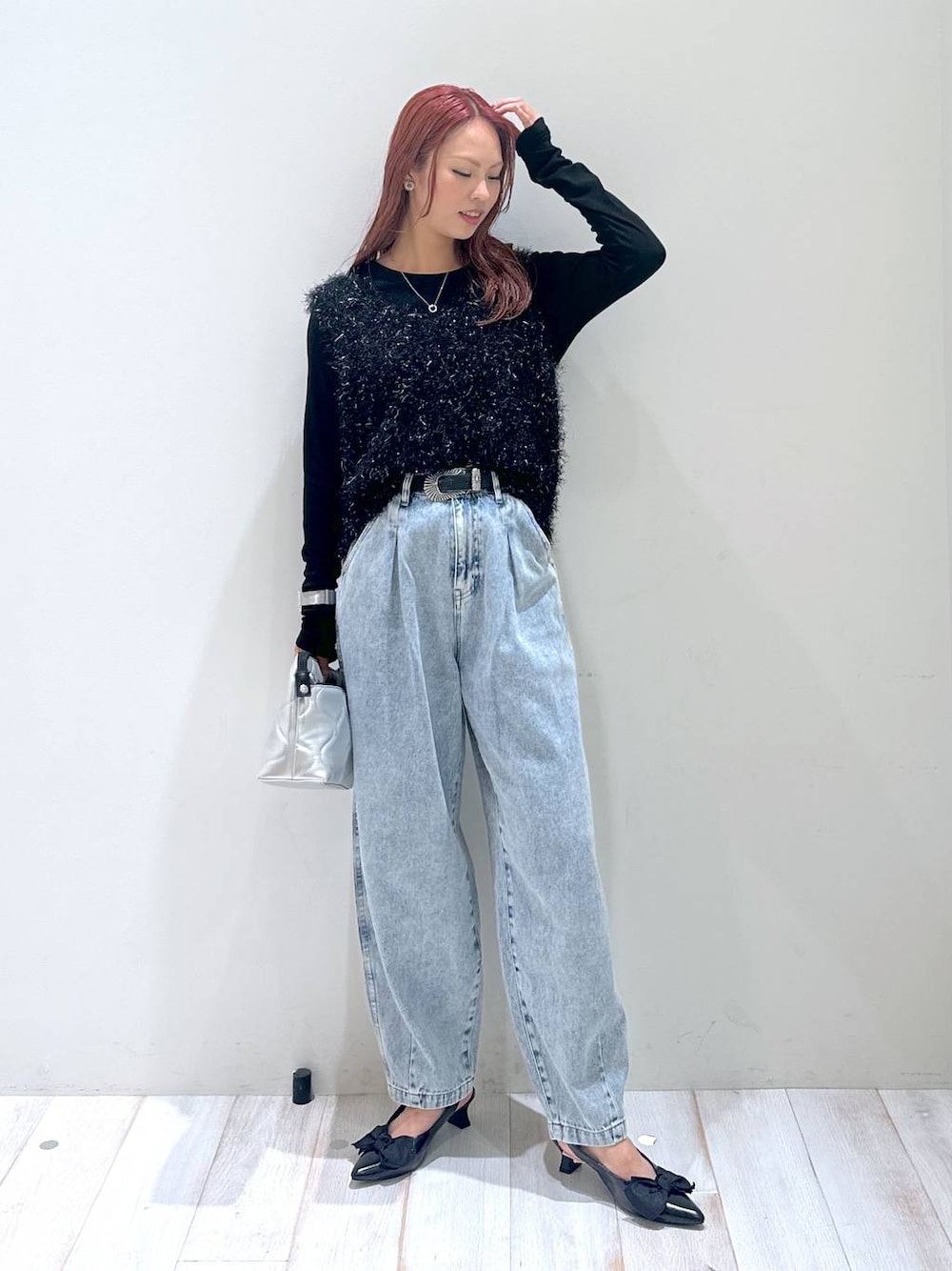 ブラック系のショルダーバッグ、ブラック系のベスト、ブラック系のパンプスを着用したレディースの秋コーディネートの1枚目の写真