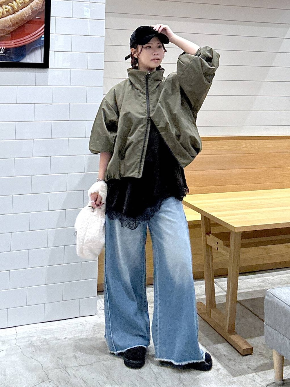 ブラック系のその他シューズ、ブラック系のデニムパンツ、ベージュ系のハンドバッグを着用したレディースの秋コーディネートの1枚目の写真