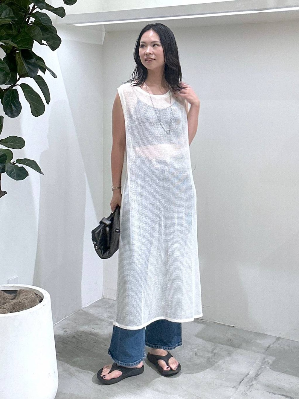 ブルー系のデニムパンツ、ホワイト系のワンピース、ブラック系のトートバッグを着用したレディースの夏コーディネートの1枚目の写真