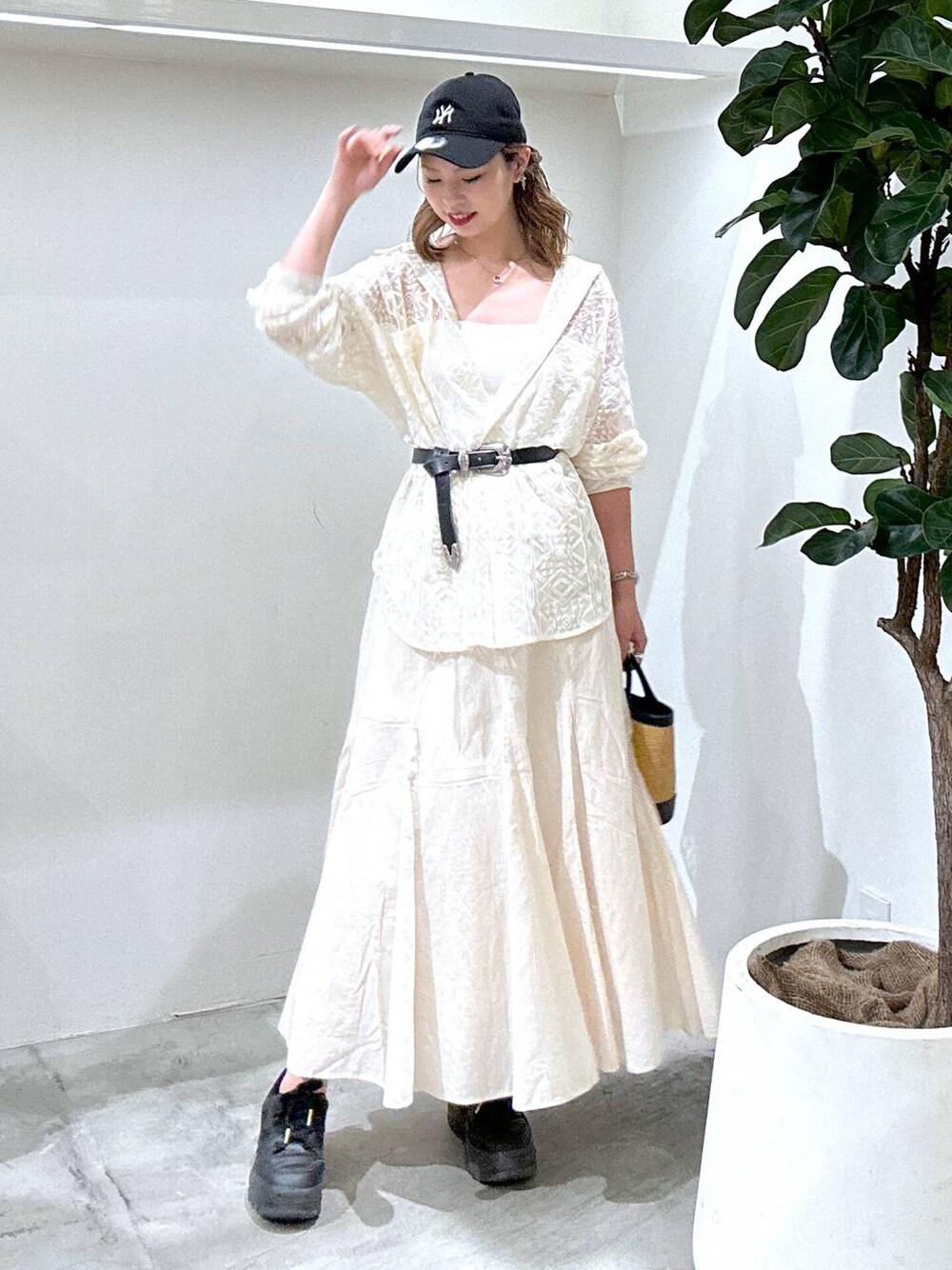 ブラック系のスニーカー、ホワイト系のシャツ/ブラウス、ブラック系のショルダーバッグを着用したレディースの春コーディネートの1枚目の写真