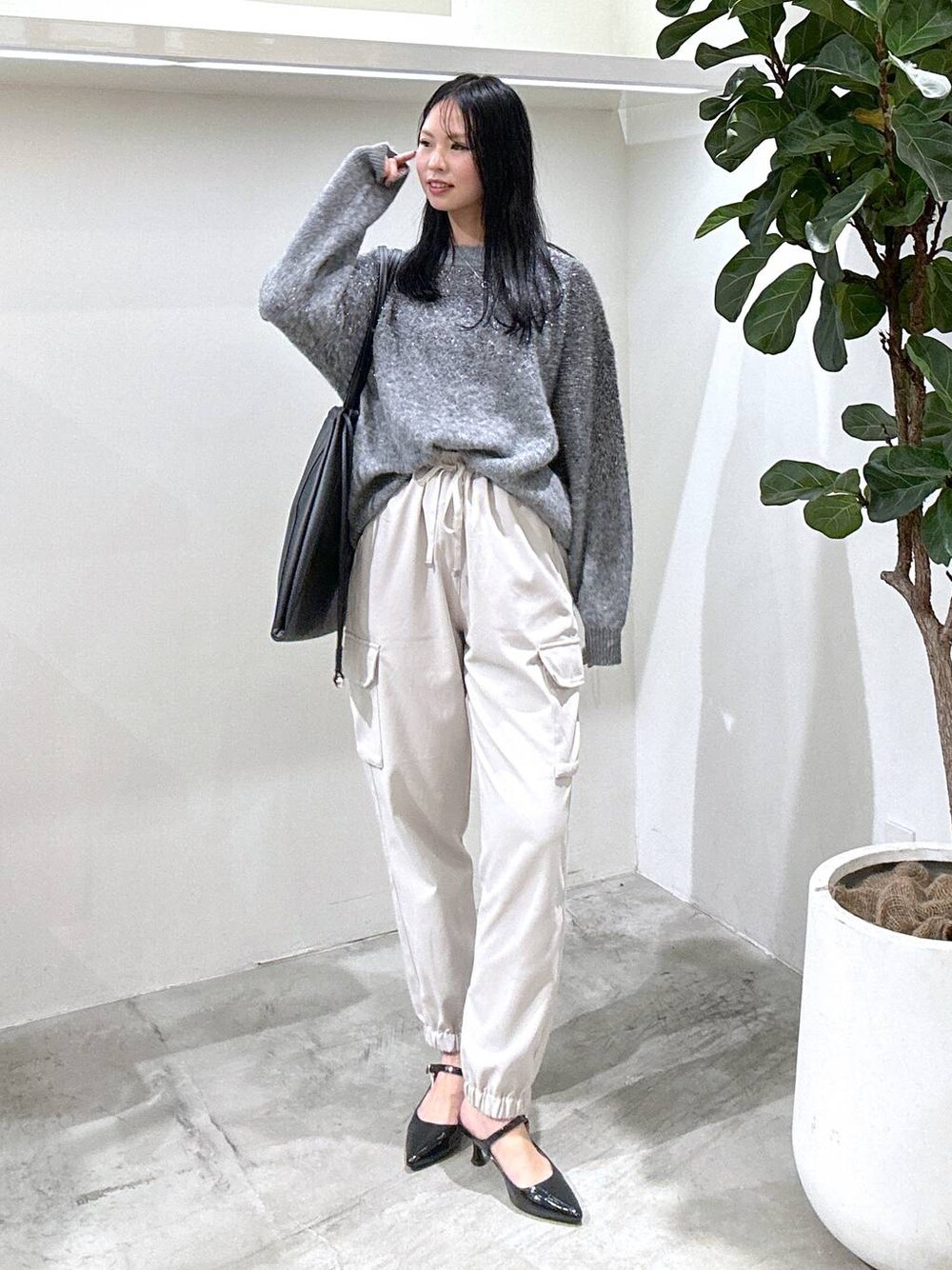 ブラック系のパンプス、ベージュ系のカーゴパンツ、グレー系のニット/セーターを着用したレディースの冬コーディネートの1枚目の写真