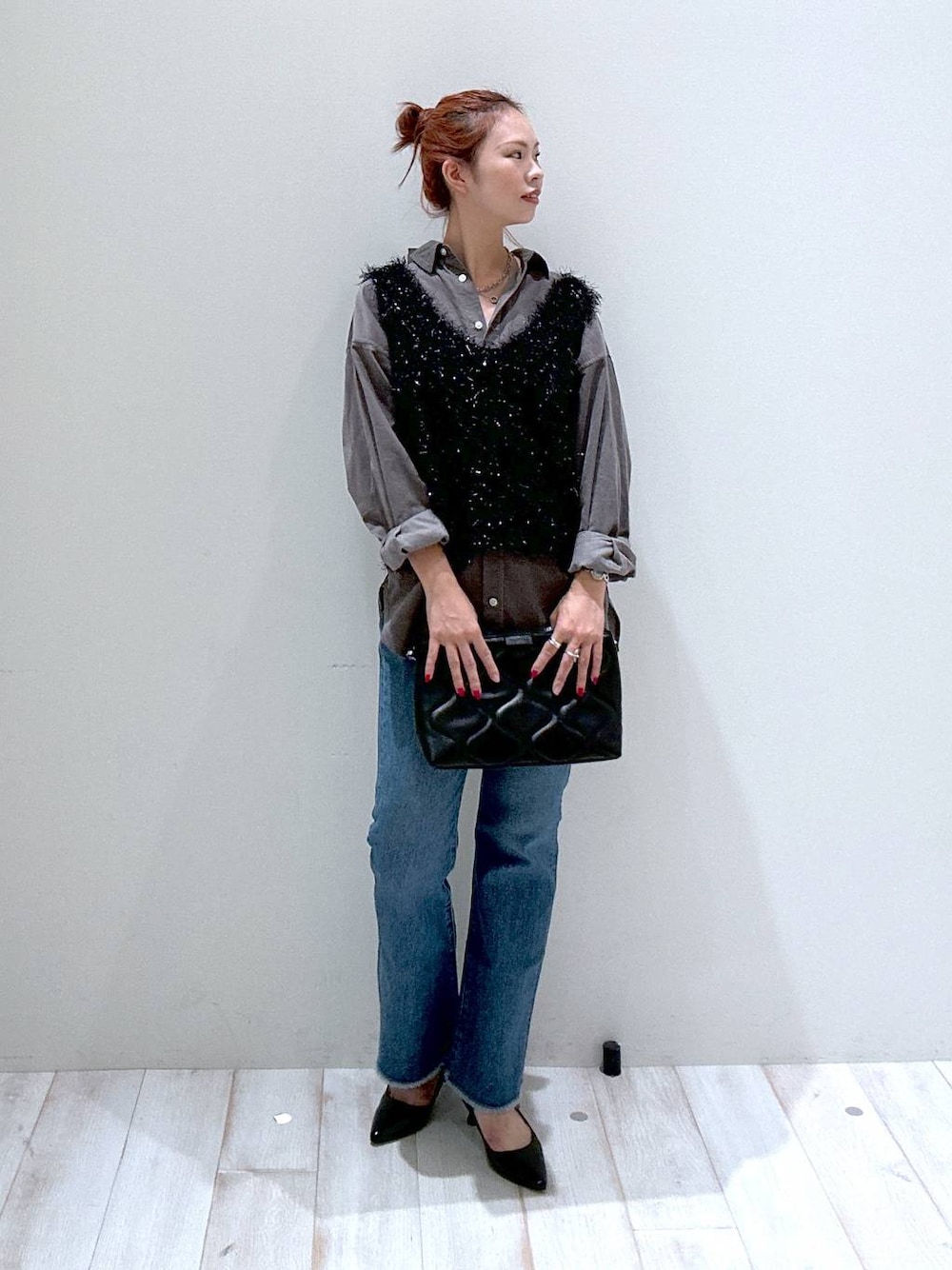 ブラック系のショルダーバッグ、ブルー系のデニムパンツ、グレー系のシャツ/ブラウスを着用したレディースの秋コーディネートの1枚目の写真