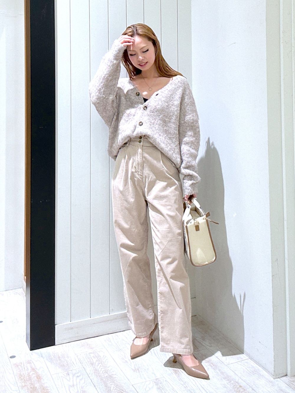 ベージュ系のその他パンツ、ブラウン系のカーディガン/ボレロ、ベージュ系のトートバッグを着用したレディースの冬コーディネートの1枚目の写真