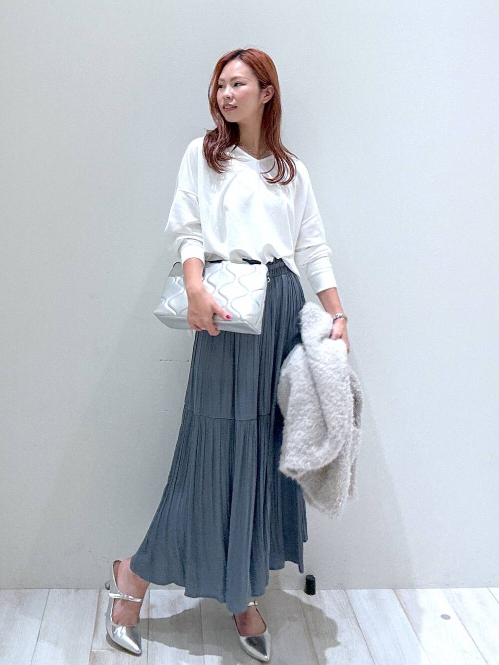 シルバー系のショルダーバッグ、ブルー系のスカート、ホワイト系のその他トップスを着用したレディースの秋コーディネートの1枚目の写真