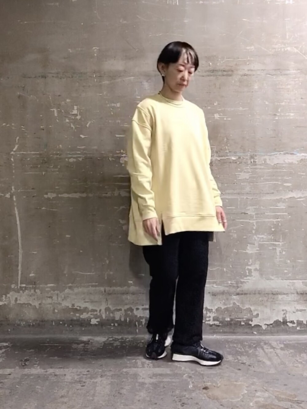 イエロー系のスウェット、ブラック系のその他パンツ、ブラック系のスニーカーを着用したレディースの春コーディネートの1枚目の写真